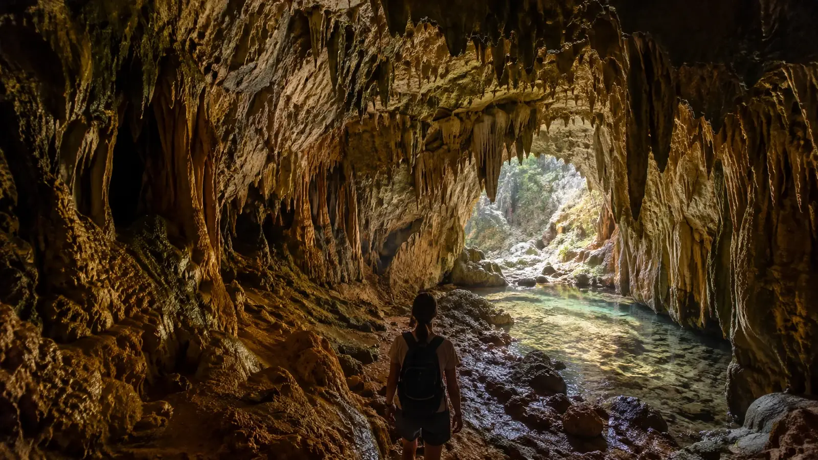 Grotta nära Aten med besökare och vattenfylld passage